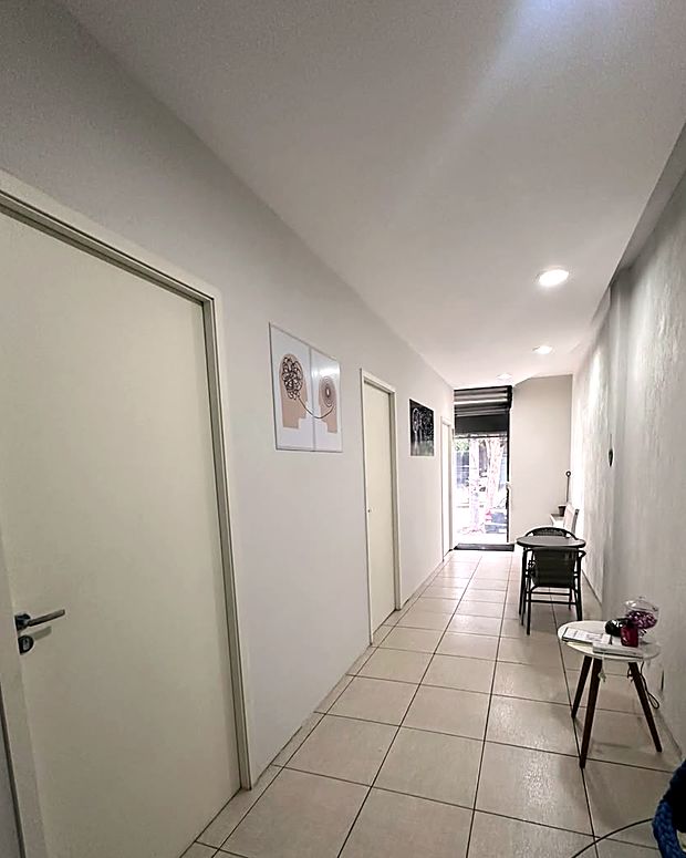 Corredor de entrada da Clínica Comportamente, com as salas de atendimento de um lado e a recepção ao fundo.