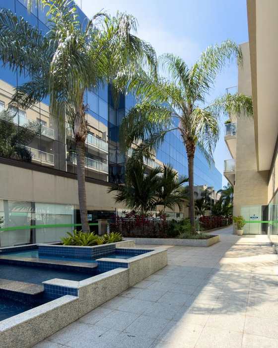 Pátio interno do edifício, com palmeiras e espelho d'água.